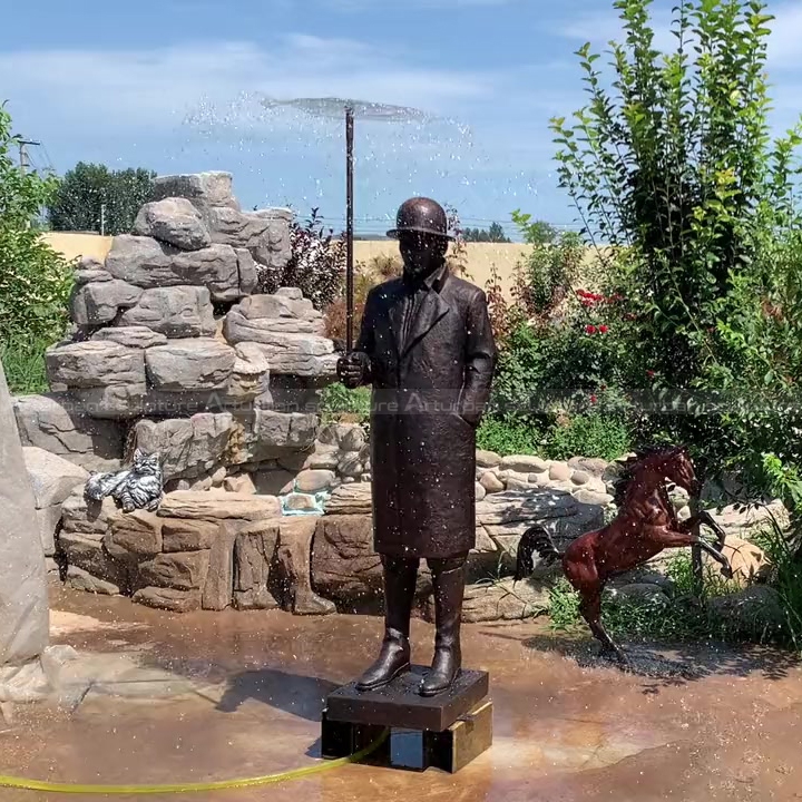 estatua de hombre con fuente de paraguas