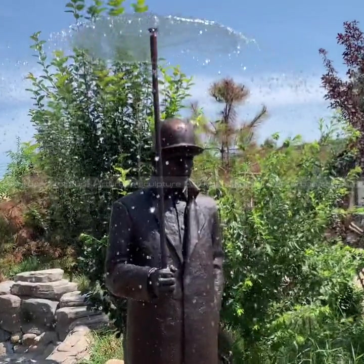 estatua de hombre con fuente de paraguas