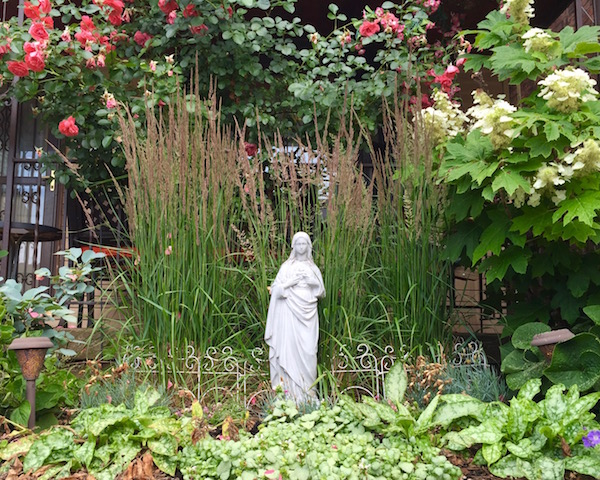statue della Vergine Maria davanti alle case