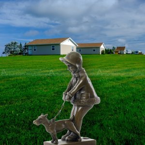 Escultura de niña paseando a un perro