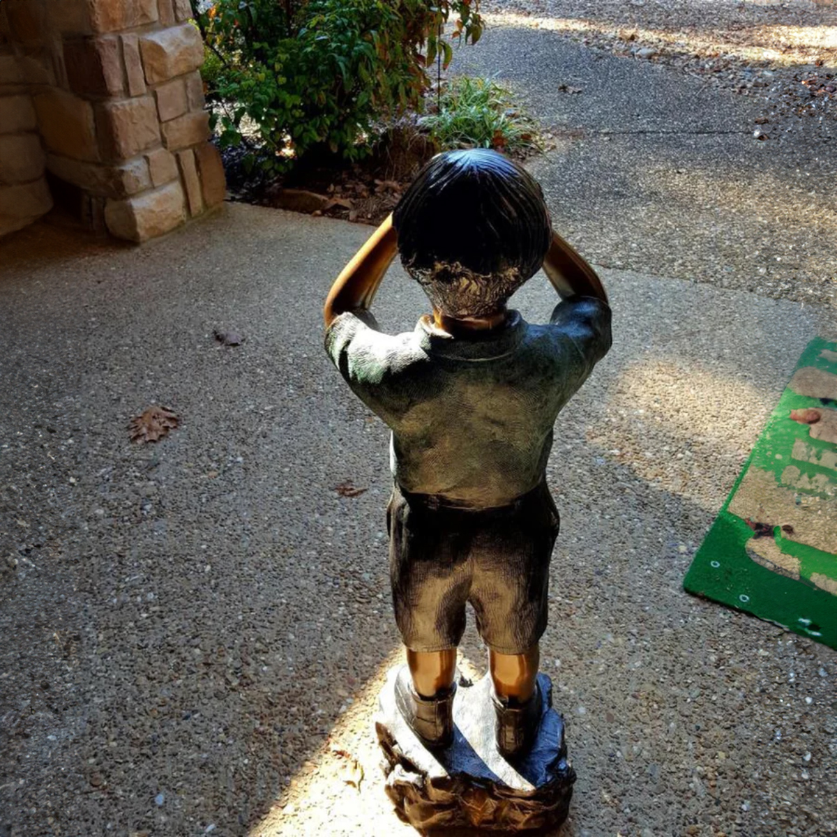 Bronzestatue eines neugierigen Jungen