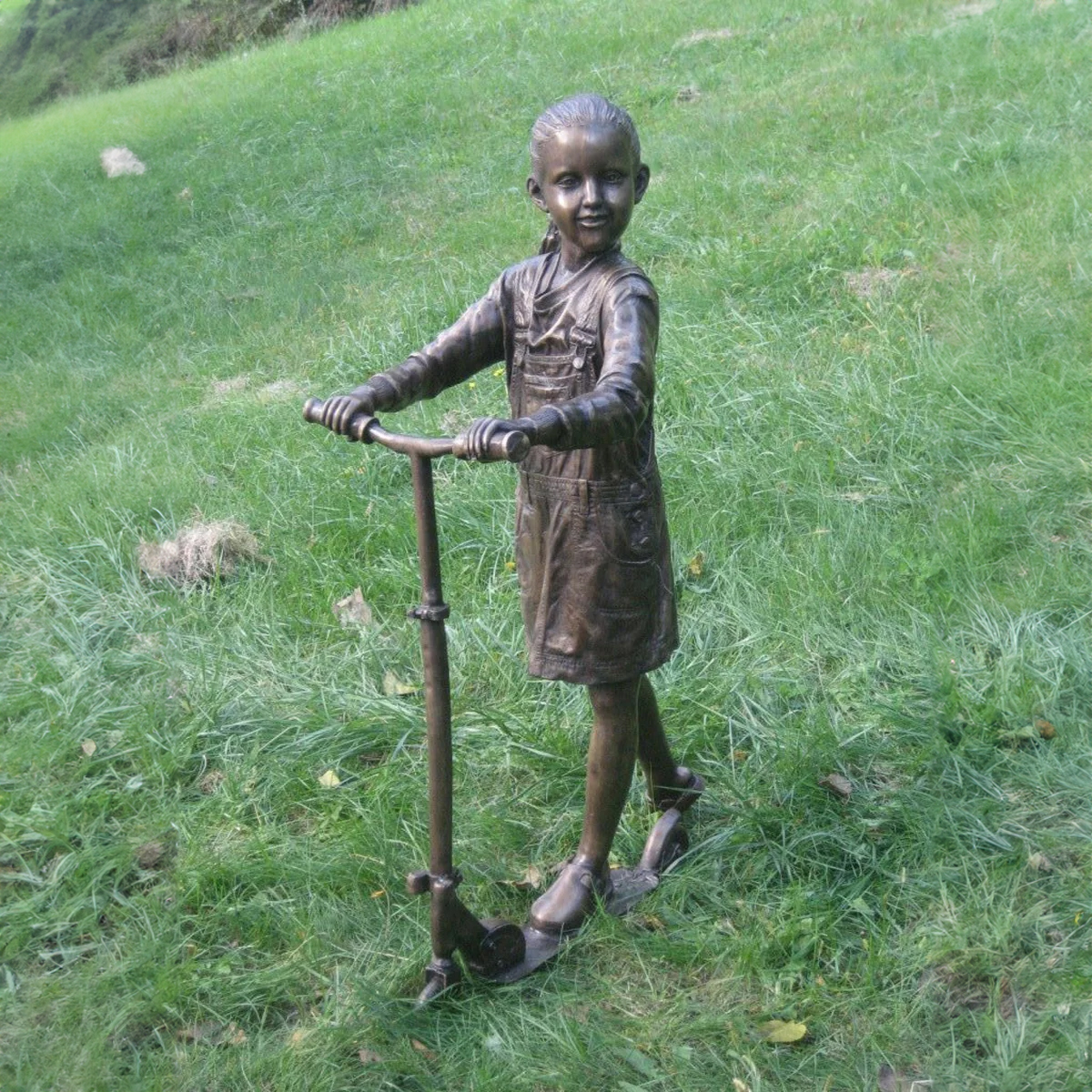 Bronzestatue eines Mädchens mit Roller