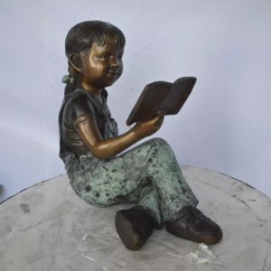 Statue eines kleinen Mädchens beim Lesen