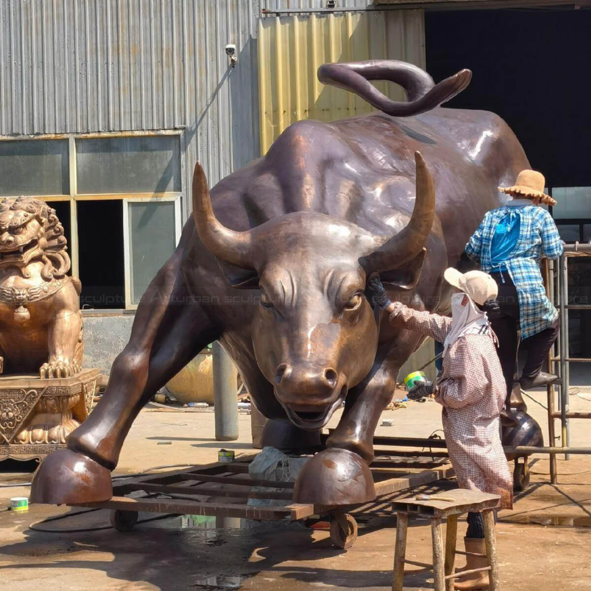 Big Bull Wall Street sculpture being polished with wax