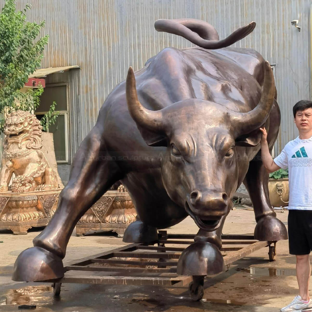 Big Bull Wall Street sculpture with a person standing next to it