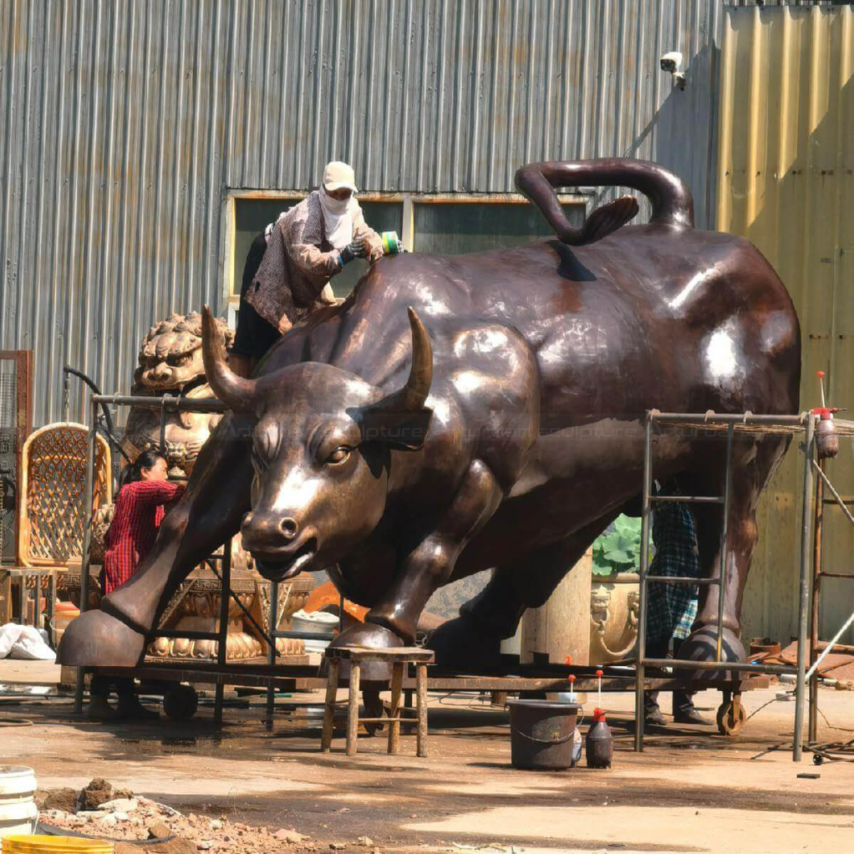 bronze Big Bull Wall Street sculpture being polished with wax
