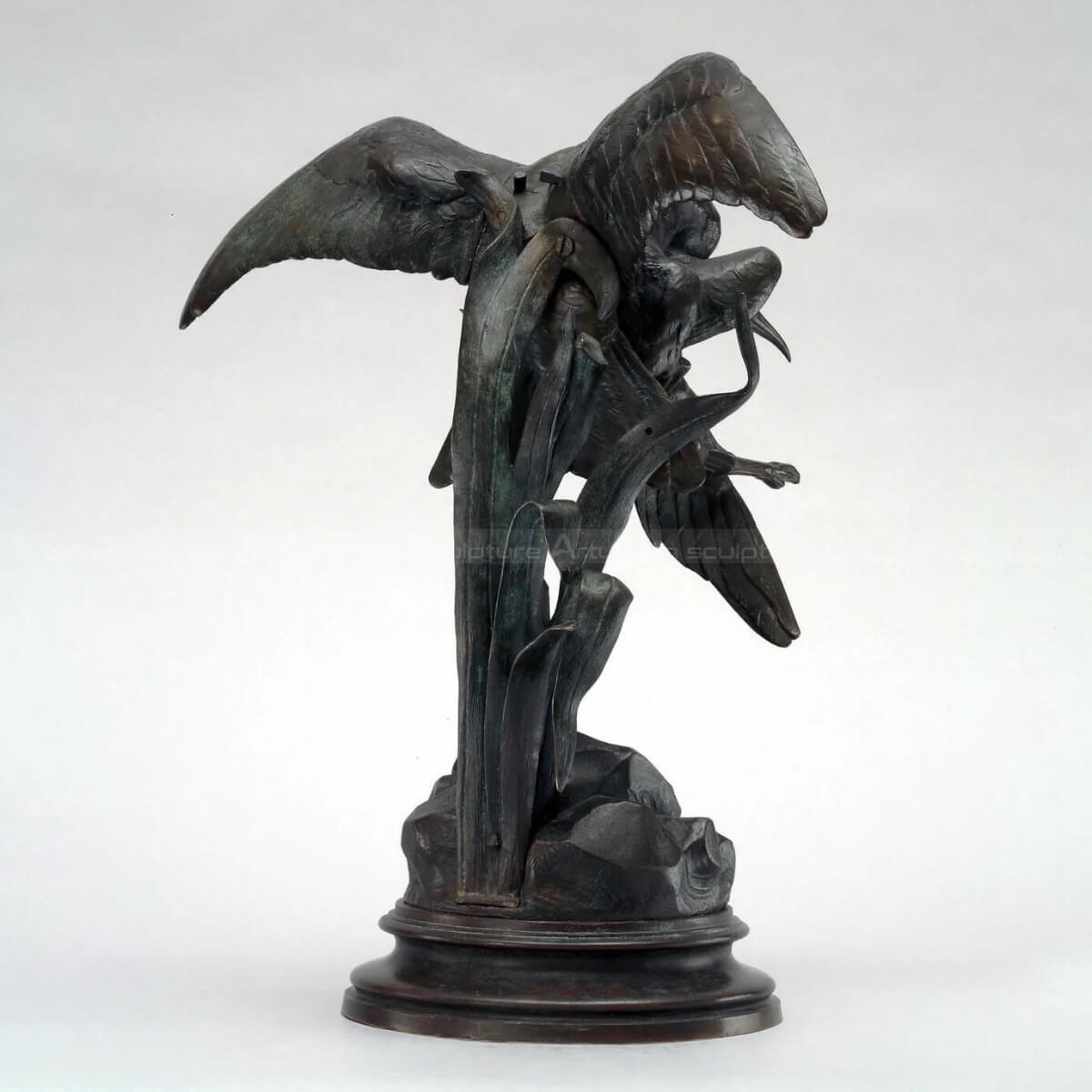 bronze black kite bird of prey capturing heron statue rear view