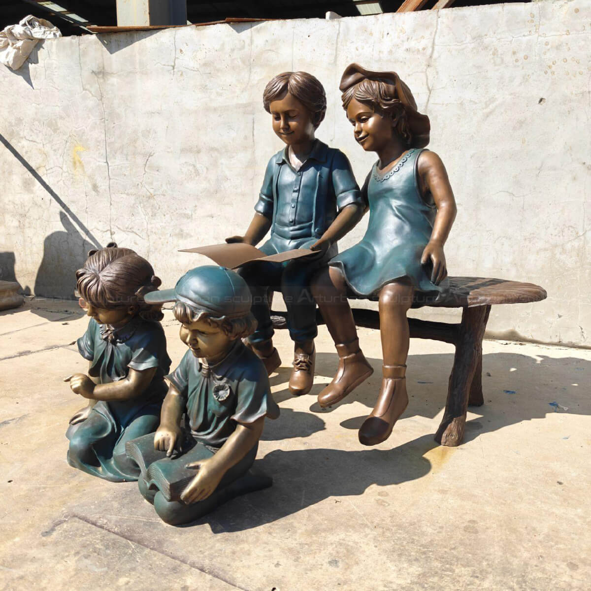 four Children Reading bronze Statue