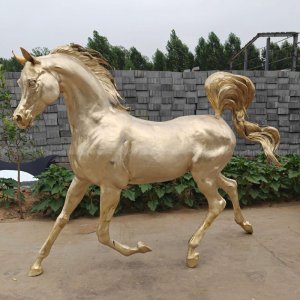 enfeite dourado de cavalo árabe em movimento, com crina e cauda detalhadas