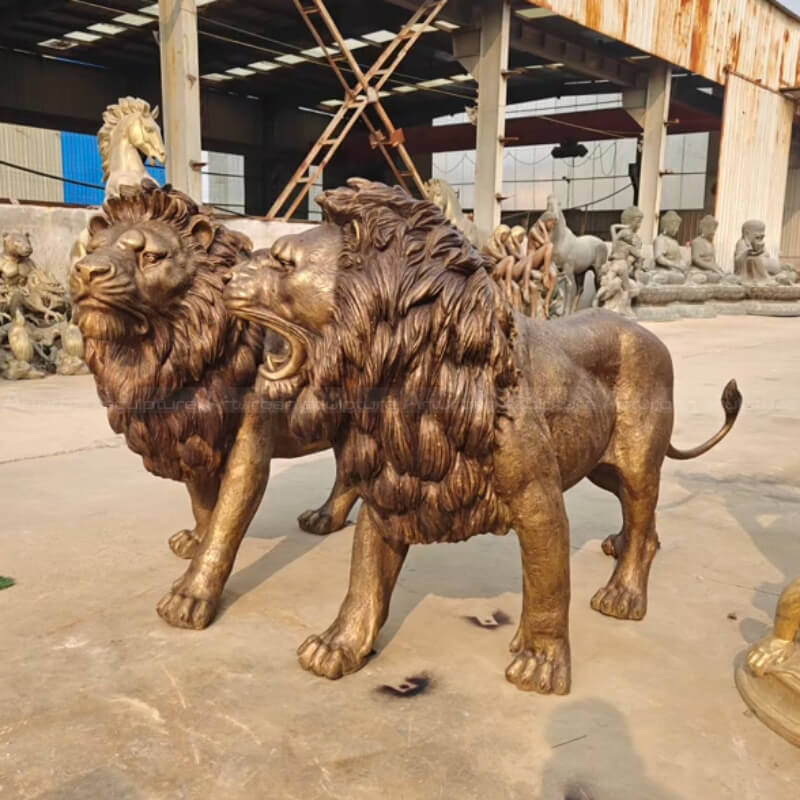 two Front Porch Lion Statues, one roaring and the other standing in a calm pose