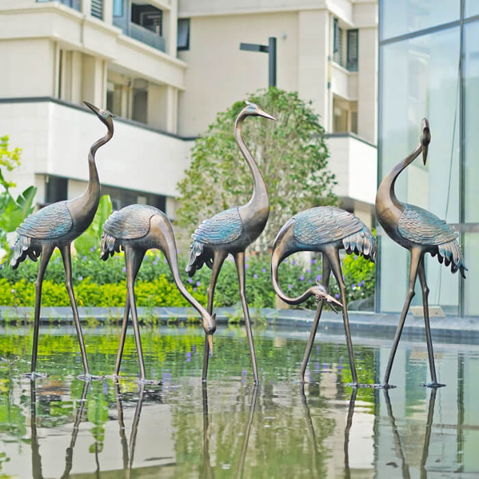5 Große Blaureiher-Gartenbronze-Statuen stehend in einem flachen Teich