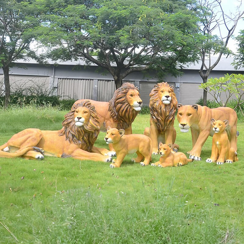 Um grande grupo de Esculturas de Leões de Jardim em fibra de vidro incluindo três leões adultos, uma leoa e vários filhotes
