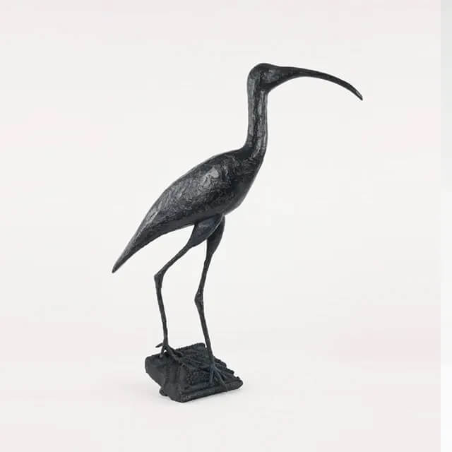 Sculpture d'Ibis élégamment debout avec son long bec courbé et ses pattes fines