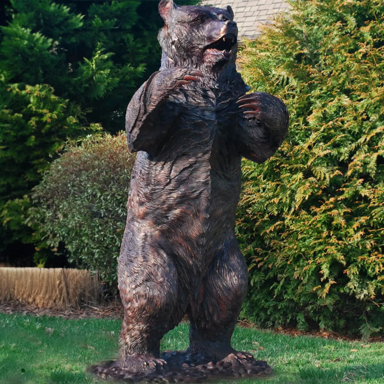 Grande scultura di orso in bronzo in piedi in una posizione allerta e difensiva