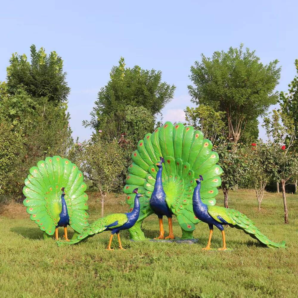 Peacock Statue showing two spread its tails and another two standing on grass land
