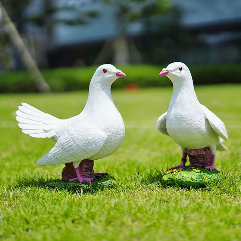 Two white Pigeon fiberglass Garden Ornaments standing on a lawn