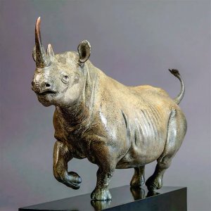 Sculpture de Rhinocéros Noir en bronze par Nick Bibby, représentant l'animal dans une pose dynamique de course avec des lignes musculaires détaillées