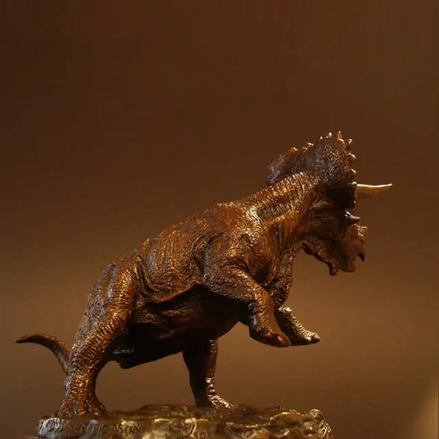 Seitenansicht der Bronce-Triceratops-Skulptur, die muskulösen Körperbau und Hauttextur zeigt