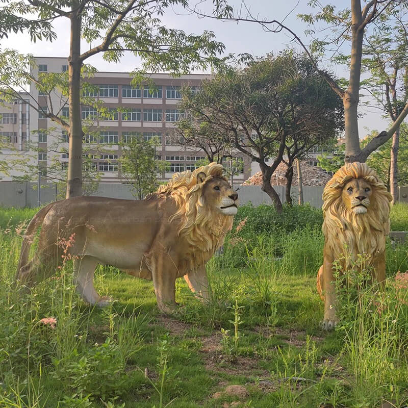 duas Esculturas de Leões Machos de Jardim em uma área gramada