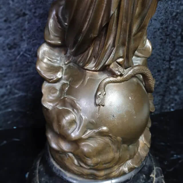 Gros plan de la base d'une sculpture représentant la Madone et l'Enfant