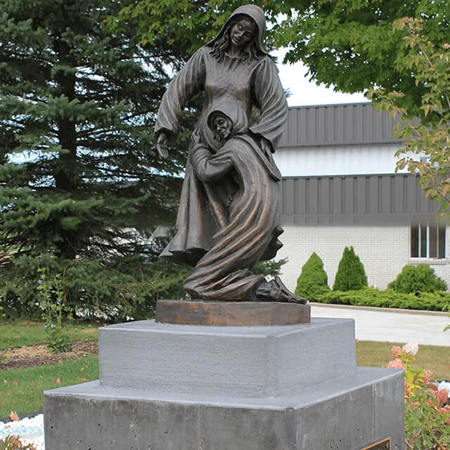 Full view of a bronze Visitation Statue depicting the biblical encounter between Mary and Elizabeth
