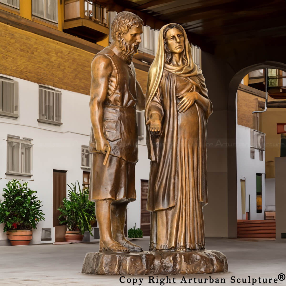 Sculpture en bronze de Marie et Joseph montrant saint Joseph debout à côté de Marie enceinte