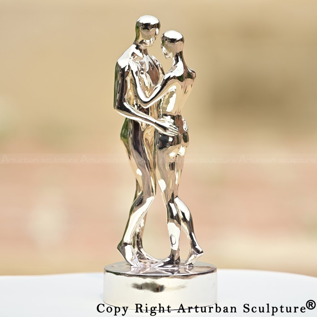 Statuette di coppia in acciaio inossidabile lucido che si abbracciano, ispirata a In Ogni Vita Ti Troverò