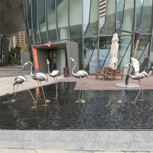 عمل فني حديث لتمثال فلامنغو خارجي يظهر طيور فلامنغو من الفولاذ المقاوم للصدأ بتصميم أنيق وأرجل طويلة