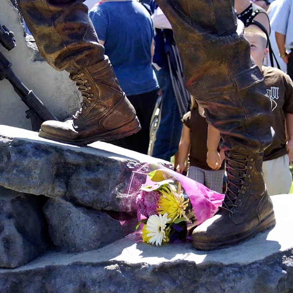 Gros plan d'une statue de soldat pour jardin présentant des bottes de combat en bronze