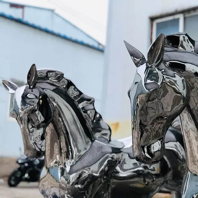 Vue rapprochée de deux sculptures de chevaux en acier inoxydable