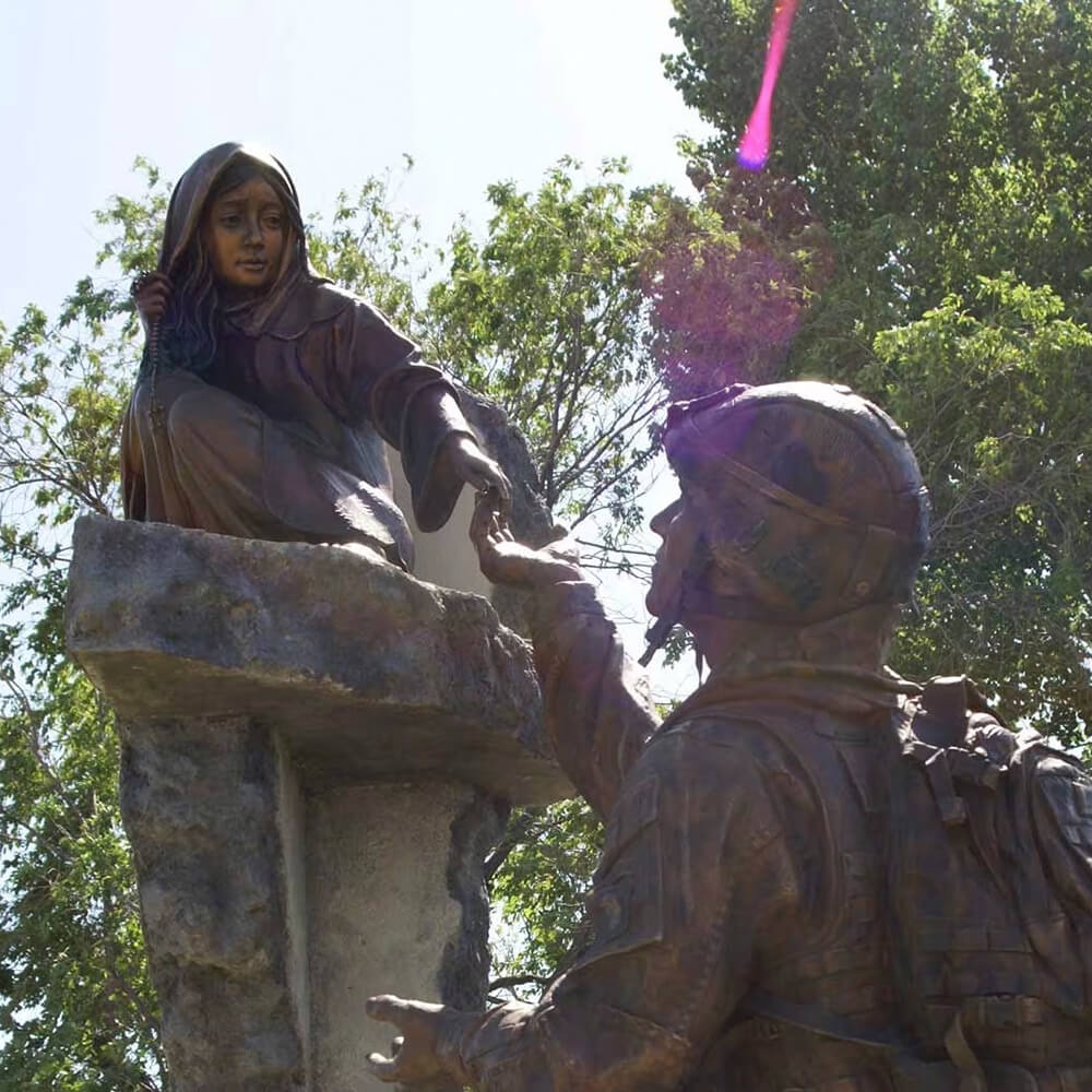 Détail de la fille dans la statue de soldat pour jardin, tendant la main dans un moment d'espoir