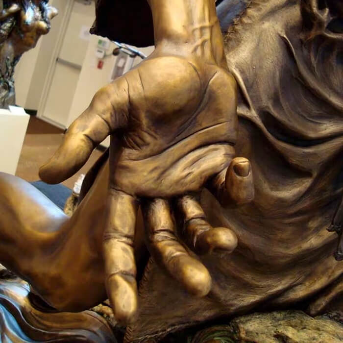 Detailed bronze hand from Baptism Statue, representing Christ's open submission during baptism