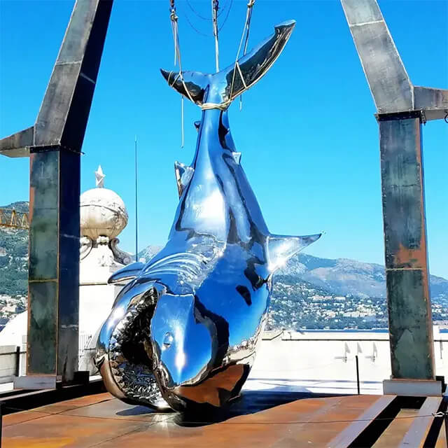 Scultura di squalo sospesa lucidata a specchio, sospesa a una struttura in acciaio, realizzata in acciaio inossidabile