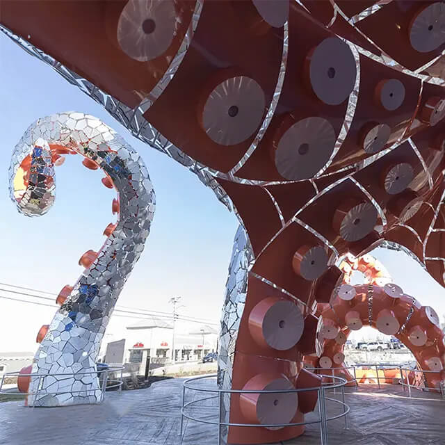 View from beneath the Giant Octopus Sculpture showcasing the stainless steel body and orange suction pads
