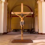 bronze Statue of Crucifixion displayed in church interior on cross