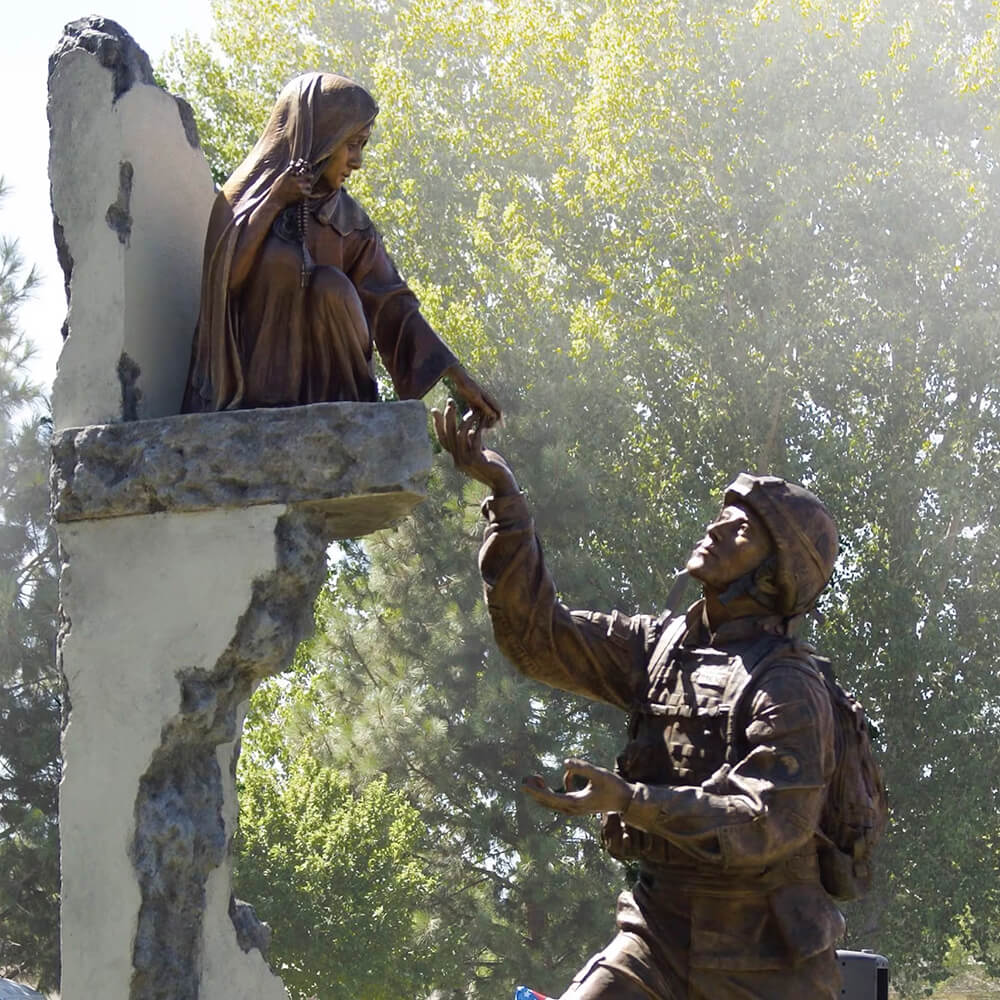 statue de soldat en bronze pour jardin montrant un soldat américain tendant la main vers un enfant assis sur un mur endommagé par la guerre