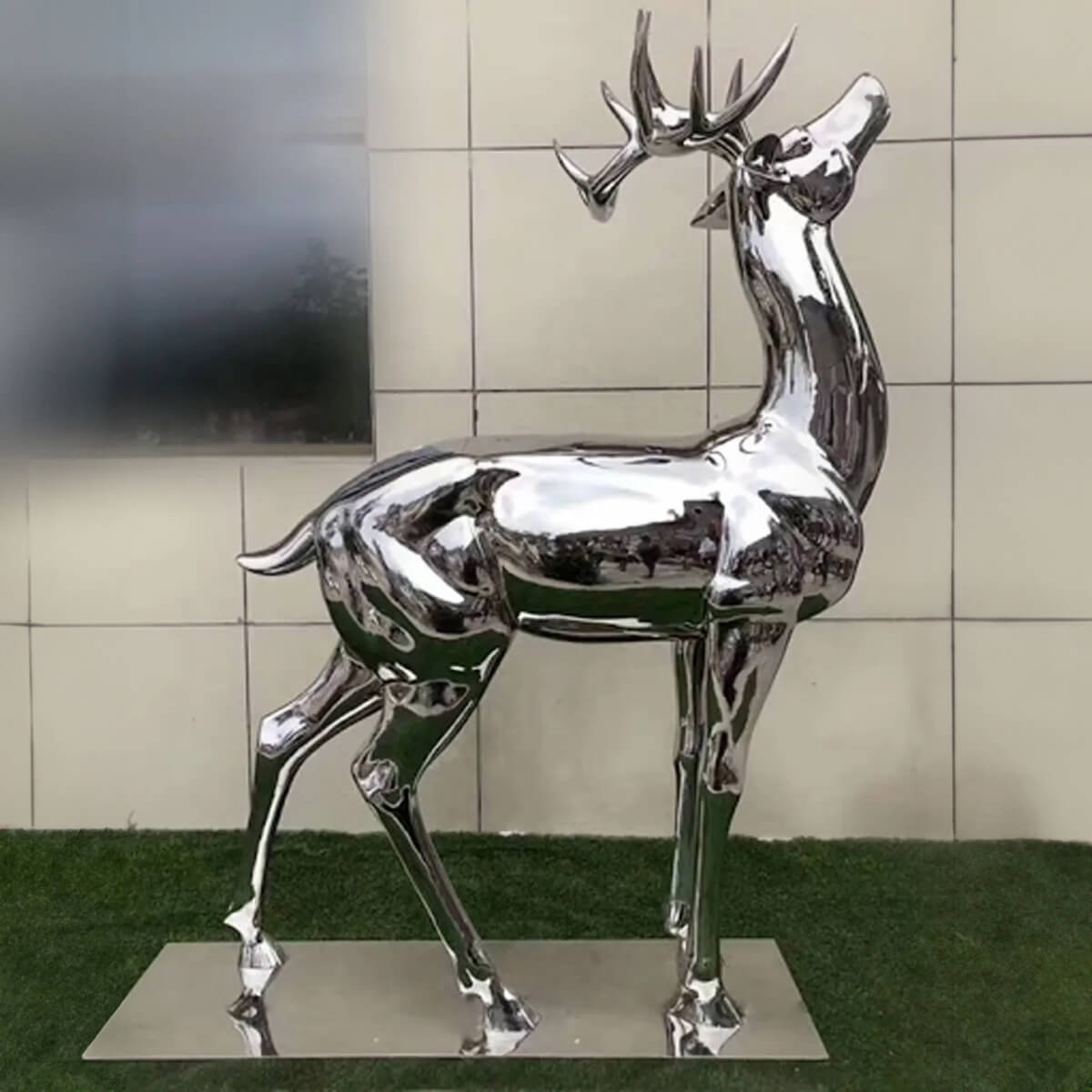 Scultura di cervo in acciaio inossidabile con superficie lucidata a specchio, caratterizzata da un design astratto di cervo in piedi