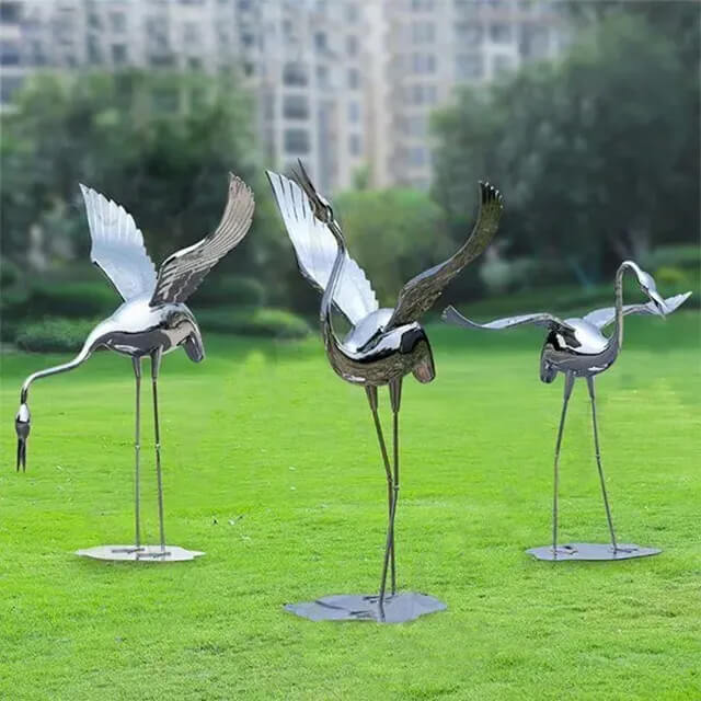 Three polished stainless steel Metal Garden Crane Statues with open wings