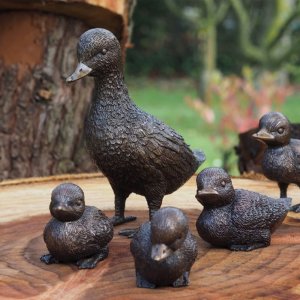 A bronze Duck Family Statues artwork showing a mother duck leading her ducklings