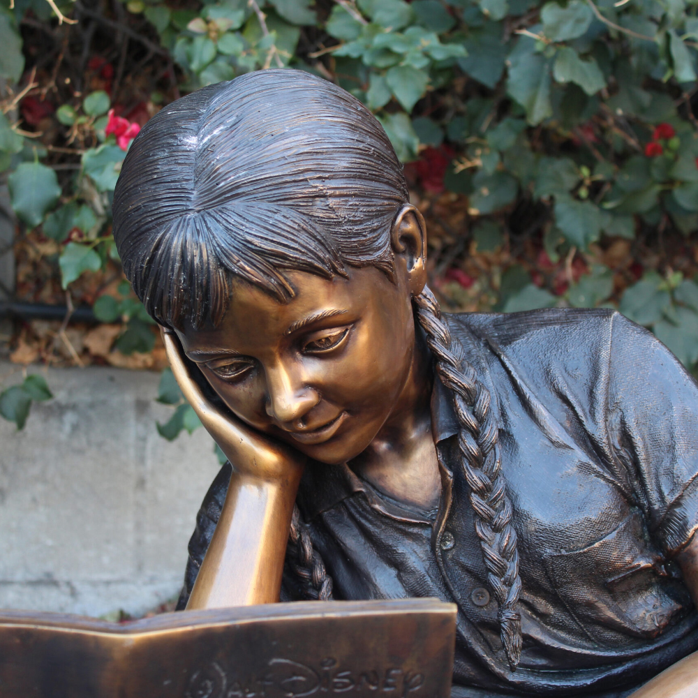 head detail of bronze sculpture gilr reading book