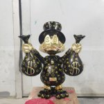 Escultura del Tío Gilito negro sosteniendo bolsas de dinero