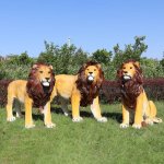 Three fiberglass Lion Lawn Statues outdoors