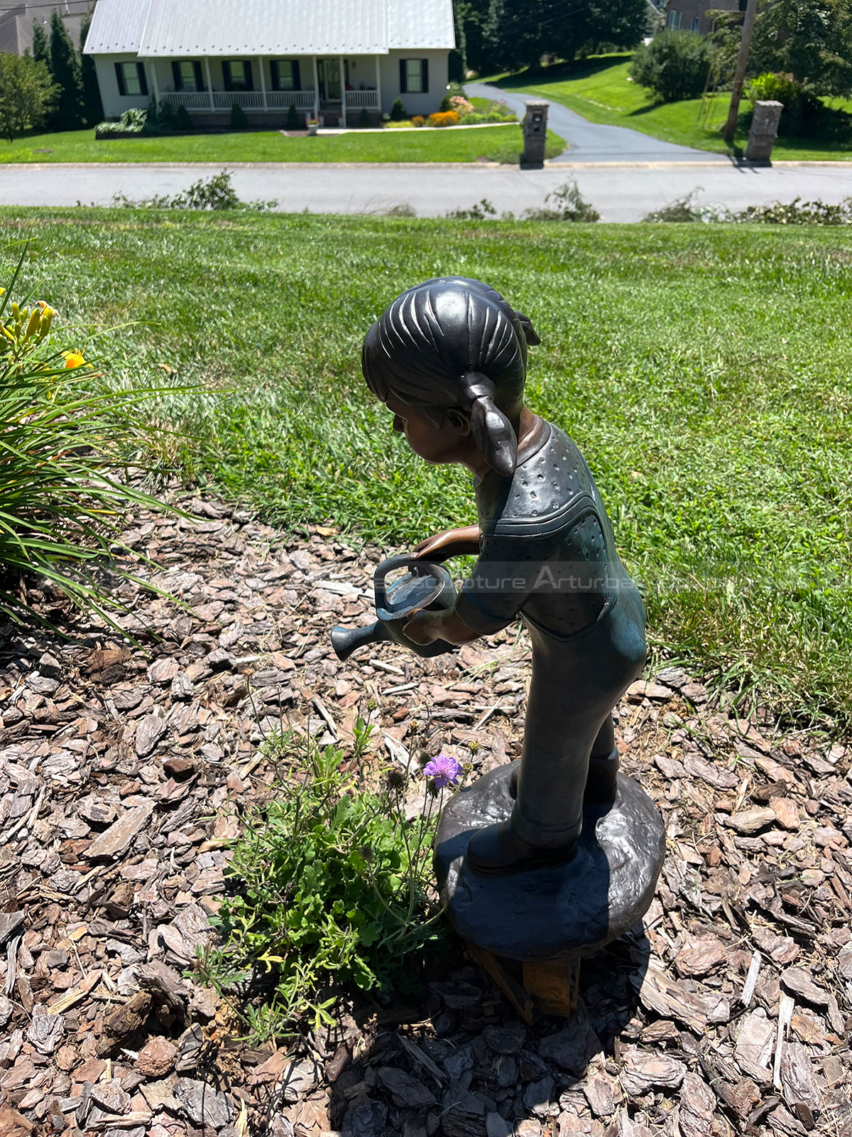Bronze child statue installed in backyard