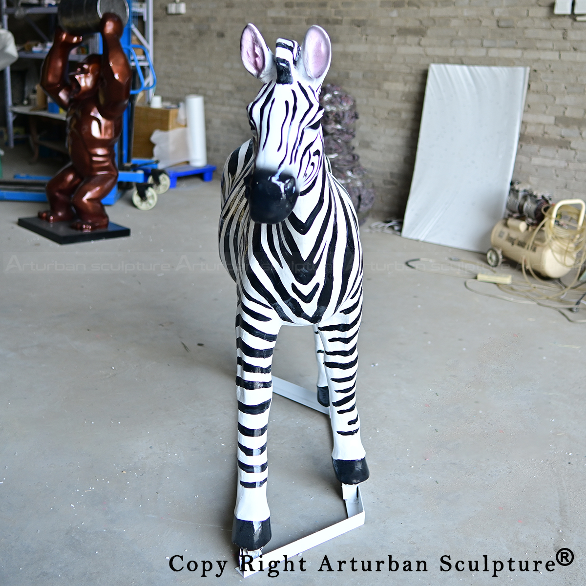 3 Fiberglass zebra sculpture beside wild kong statue