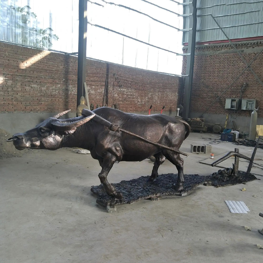 Sculpture en bronze d'un buffle d'eau marchant avec un harnais agricole