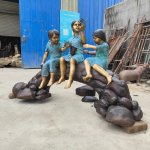 Estatua de niños sentados sobre un tronco - Image 1