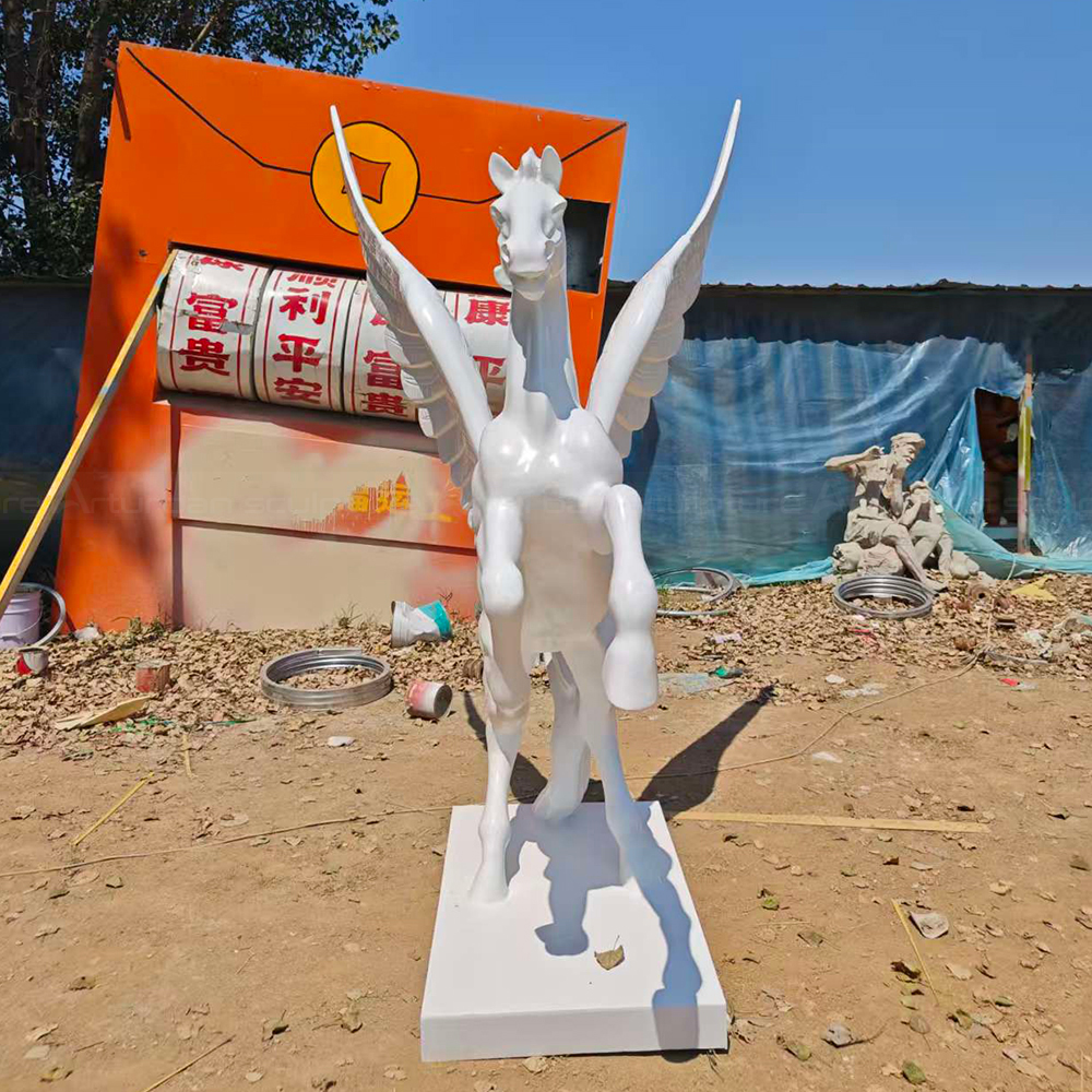 Sculpture de cheval volant en fibre de verre dans une cour extérieure